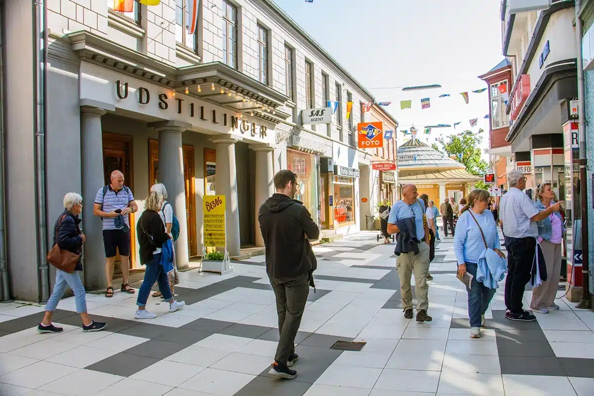 Butiksgade med udstillinger og besøgende i Den Gamle By 1974. Butiksgade med udstillinger og besøgende i Den Gamle By 1974.