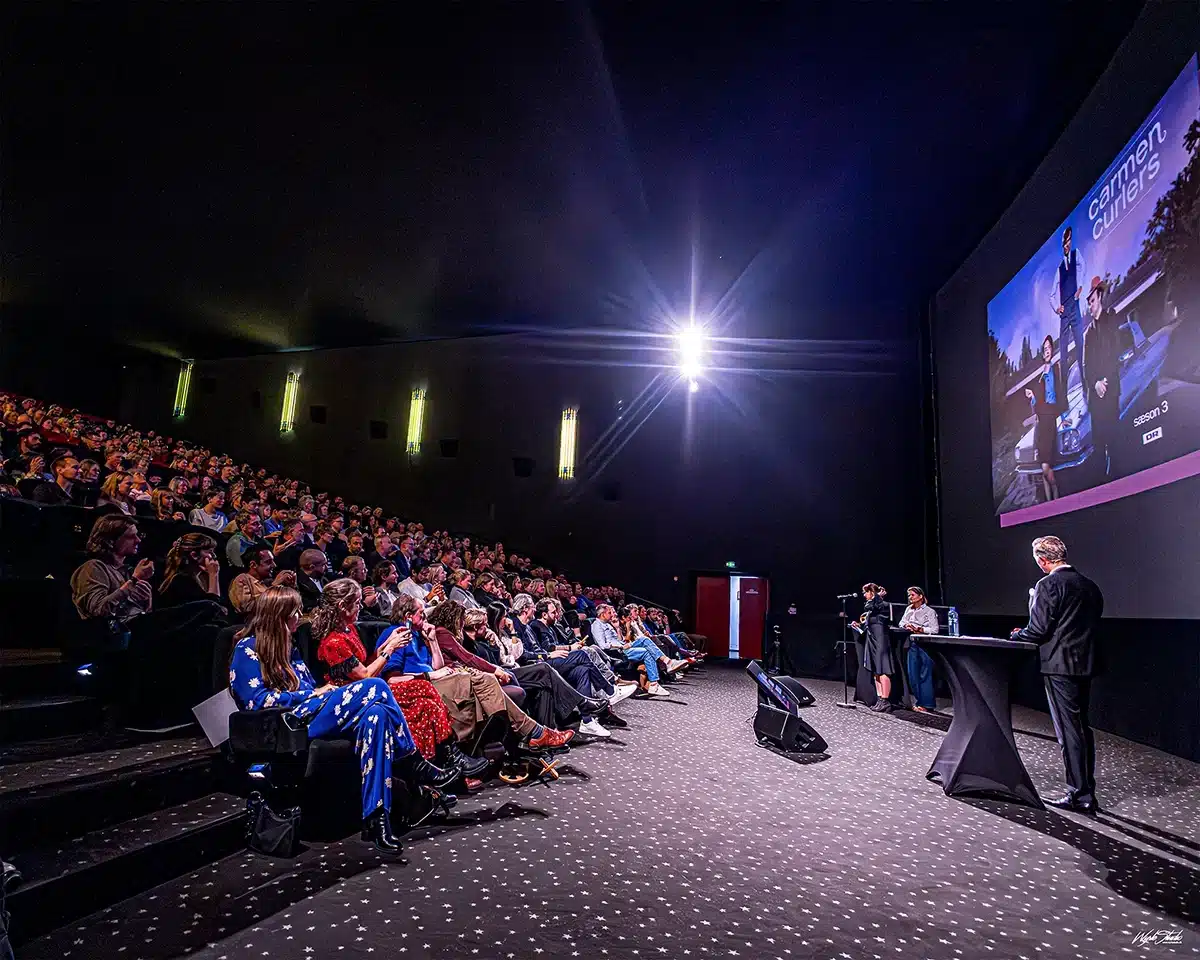 Publikum følger intenst med, mens Series Awards 2025 uddeles fra scenen i VUE Biografen med stor sal og lærred i baggrunden Clara Dessau og Afshin Firouzi på den røde løber ved Serie Awards 2025