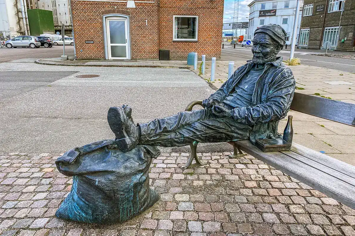 Skulptur ved Mellemarmen havn med havnearbejder på bænk Skulptur ved Mellemarmen havn med havnearbejder på bænk