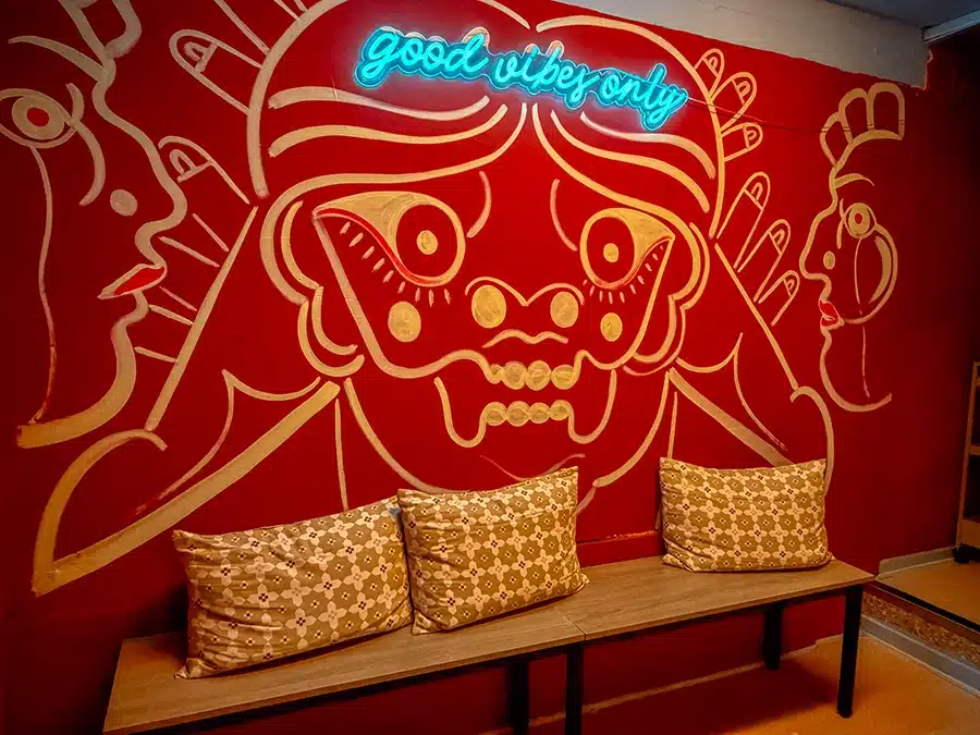 Farverigt vægmaleri med neon-skiltet Good Vibes Only i kælderen hos restaurant Alma i Aarhus.