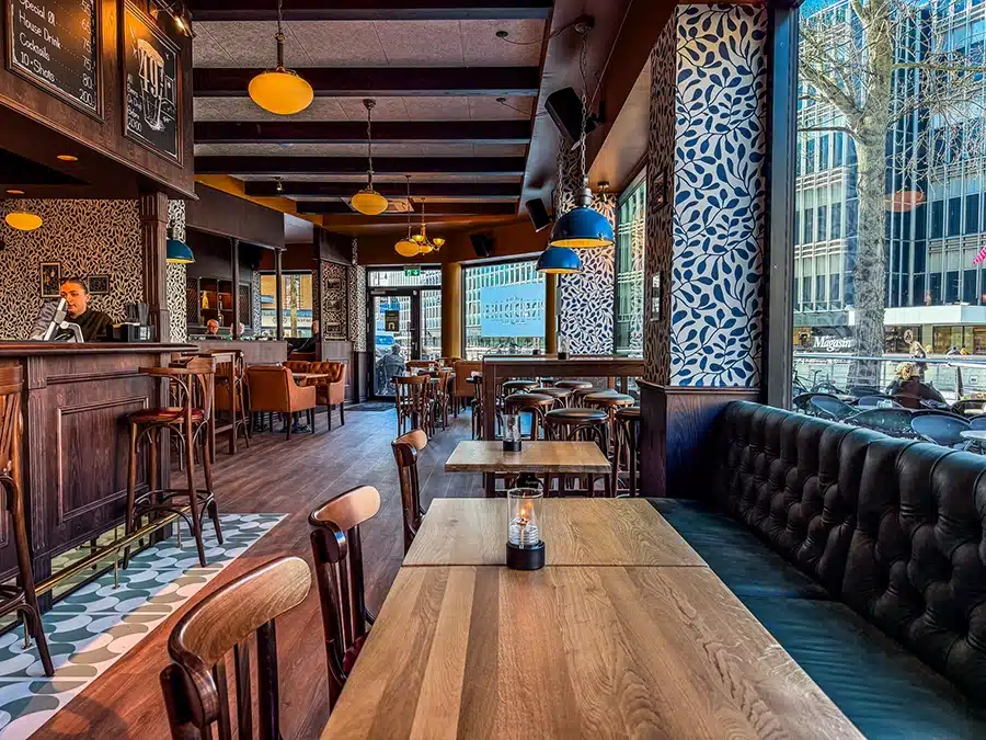 Freddies English Pub på Åboulevarden 39 i Aarhus med store vinduespartier, mørkegrønne lædersofaer og udsigt til livet ved åen