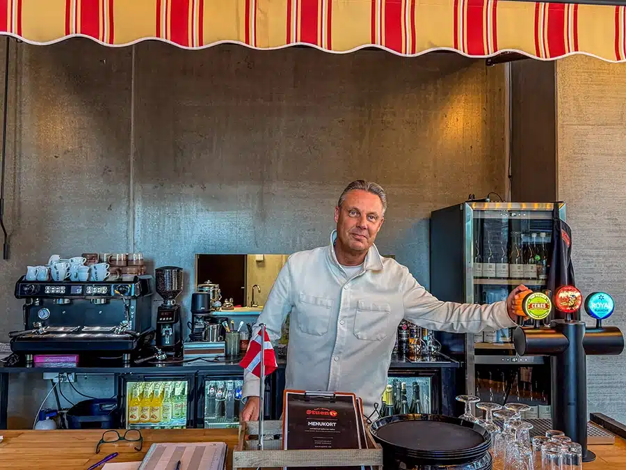Indehaver bag baren hos caféen Stuen Til Venstre i Aarhus med kaffemaskine, ølhaner og menukort