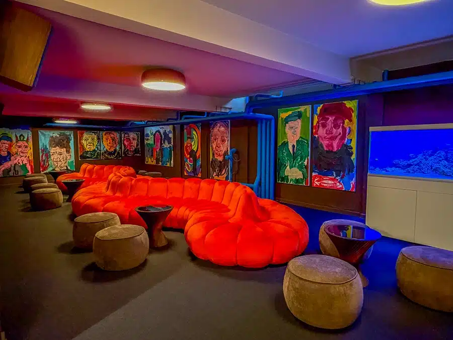 Kælderlounge hos Café Broløs i Aarhus med stor, slangende orange sofa