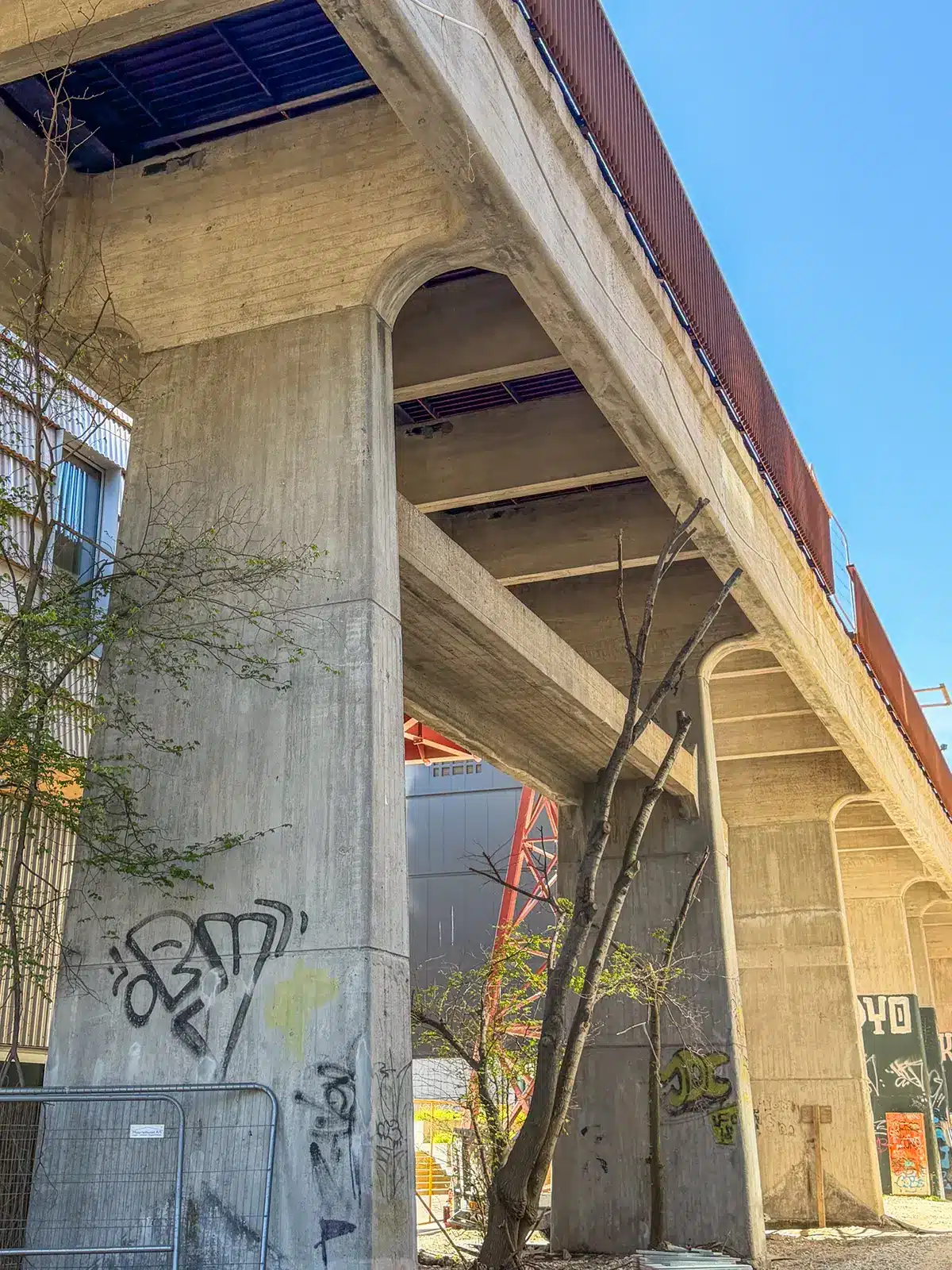 Kulbroens betonpiller set nedefra med graffiti og spinkle træer på Sydhavnen Kulbroens betonpiller set nedefra med graffiti og spinkle træer på Sydhavnen