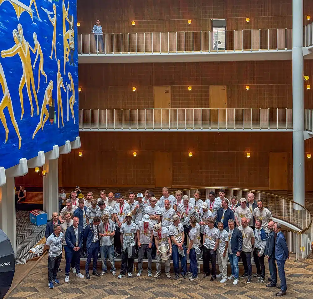 Hele AGF-holdet og staben samlet til fælles foto i Aarhus Rådhus' atrium under det store kunstværk