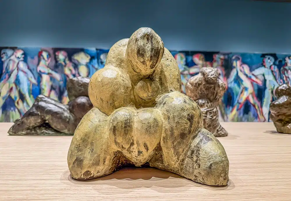 Skulptur af sammenkrøllet menneskekrop foran blå væg, Svend Wiig Hansen på ARoS