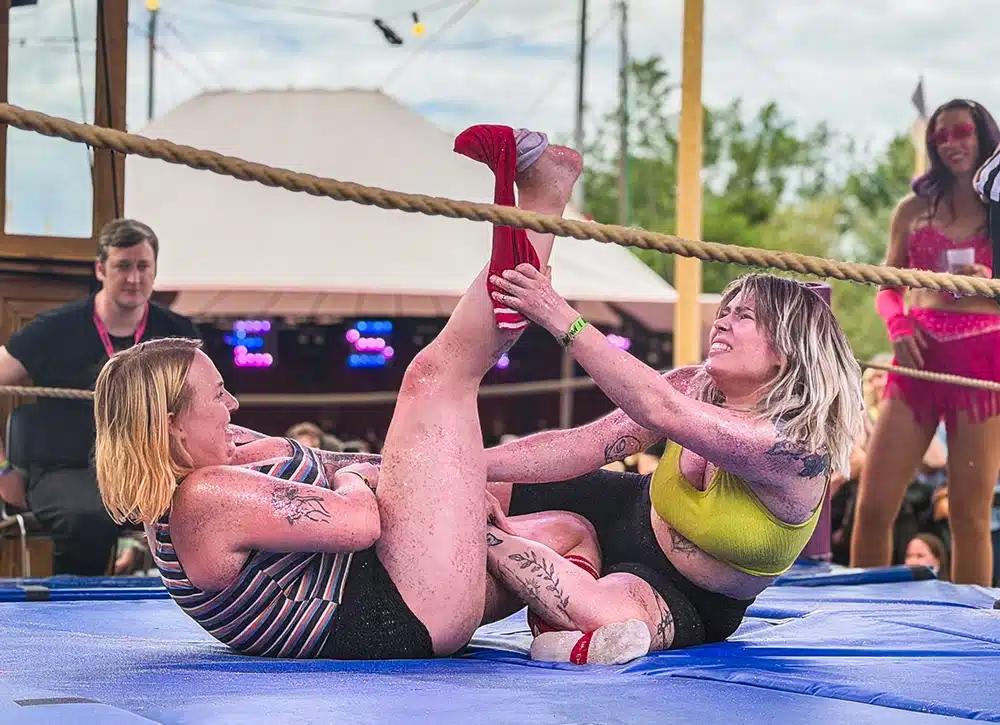 To kvinder kæmper i glitter wrestling ringen på NorthSide 2026 Sideshow, begge dækket af glimmer