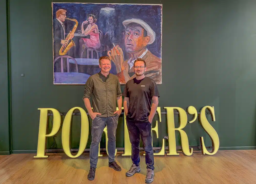 To ejere foran Porter’s-skilt og jazzmaleri på Sydhavnen To ejere foran Porter’s-skilt og jazzmaleri på Sydhavnen