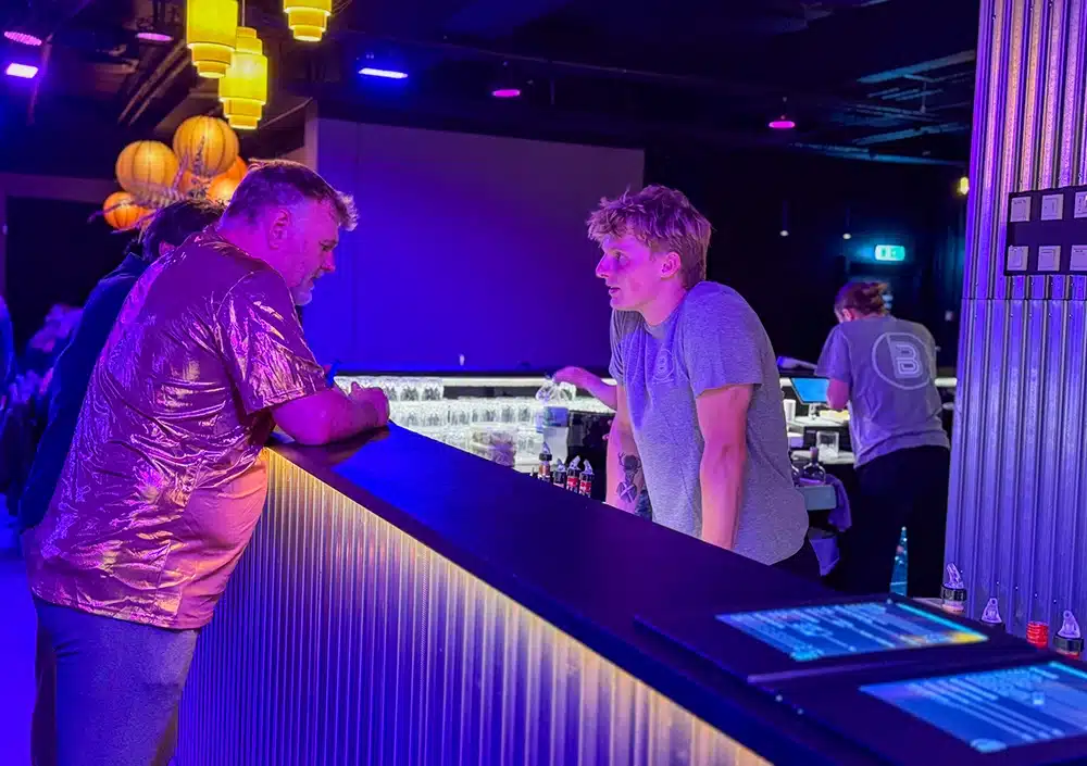 Bartender betjener en gæst ved baren i The Ballroom Bartender betjener en gæst ved baren i The Ballroom