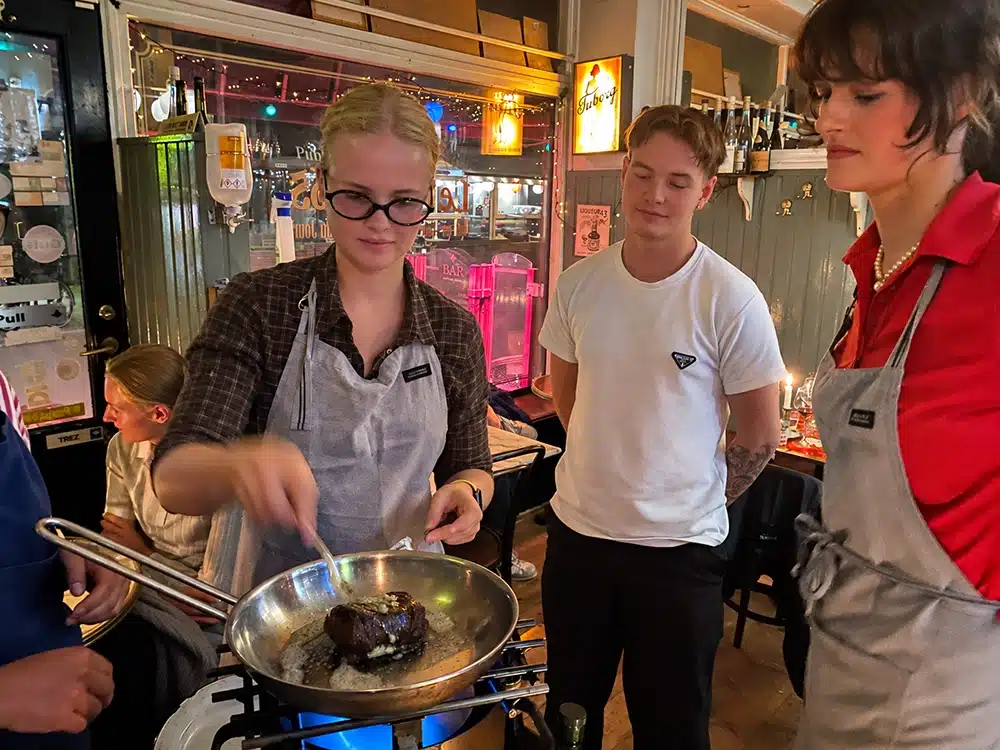 Tjener flamberer kød ved bordet på Klassisk Bistro Tjener flamberer kød ved bordet på Klassisk Bistro